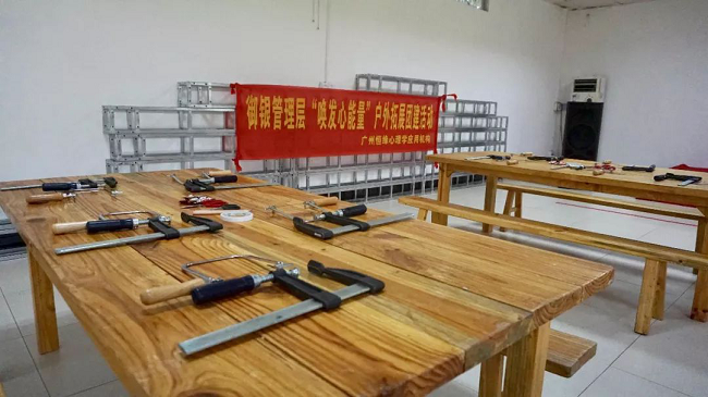 　测试不是目的，在香草拓展基地的冠军营地，培训机构还特别请来了黄大仙为大家解读迷津，让参训的管理人员重新认识心底的自己，同时理解沟通中可能出现的障碍，与此同时，还借助测试引导管理人员转换角度、换位思考，借此提高沟通的效能。不仅如此，黄大仙还在介绍过程中为参训人员提供了一些提升管理的沟通小秘籍。     经历匠人精神     　　没有真正的经历，又谈何真正的理解与认识。管理人员来自不同的部门、不同的领域，为了加深理解与认识，培训进入了第二个环节——体验木艺工作坊。每人一个F夹、一把手持锯，一到两块木板、几幅看似有些朦胧的造型图、铅笔、剪刀、砂纸，还有作品任务书，工作坊正式启动。
